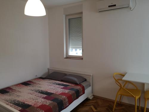 Un dormitorio pequeño con una cama y una ventana. en Clock Tower Apartments, en Podgorica