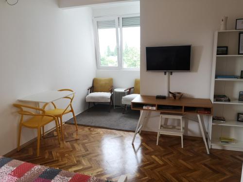 sala de estar con escritorio, TV y sillas en Clock Tower Apartments, en Podgorica