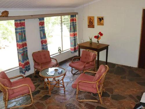 a living room with chairs and a table at Goederus Guest Farm in Sterkspruit