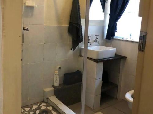La salle de bains est pourvue d'une douche et d'un lavabo. dans l'établissement Goederus Guest Farm, à Sterkspruit