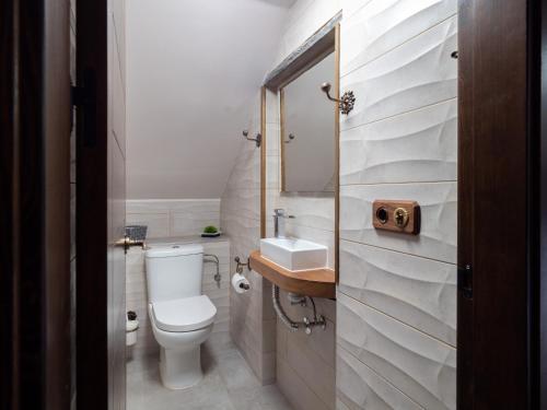 a white bathroom with a toilet and a sink at Casa Rural Perico in Fiscal