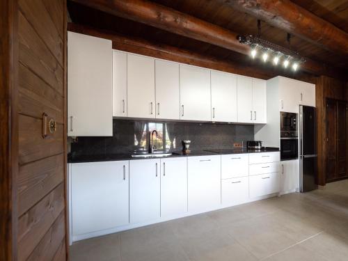 a white kitchen with white cabinets and a door at Casa Rural Perico in Fiscal