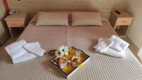 a tray of food on top of a bed at Hotel Eliani in Grado
