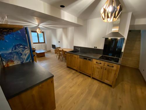 une grande cuisine avec un comptoir et une salle à manger dans l'établissement Appartement 75m2 duplex au cœur du village de Queige, à Queige