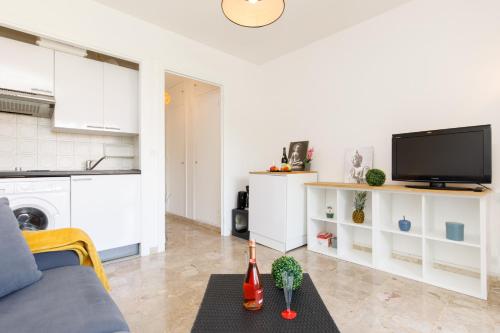 un salon avec un canapé et une télévision dans l'établissement Nelson Cannes YourHostHelper, à Cannes