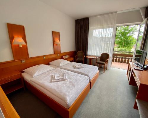 AltenmedingenにあるAdamidis Hotelのベッドとテレビが備わるホテルルームです。
