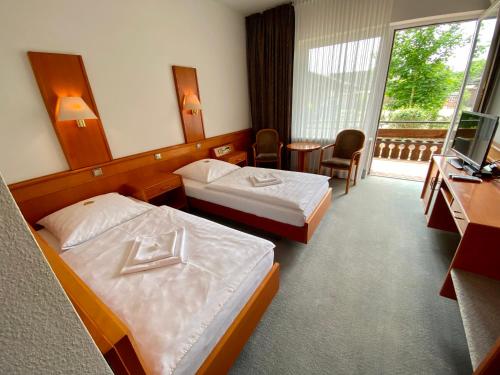 AltenmedingenにあるAdamidis Hotelのベッド2台とテレビが備わるホテルルームです。