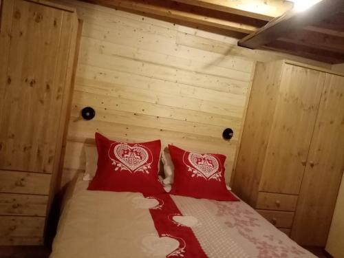 a bedroom with two red pillows on a bed at Casa vacanza il Granaio in La Thuile