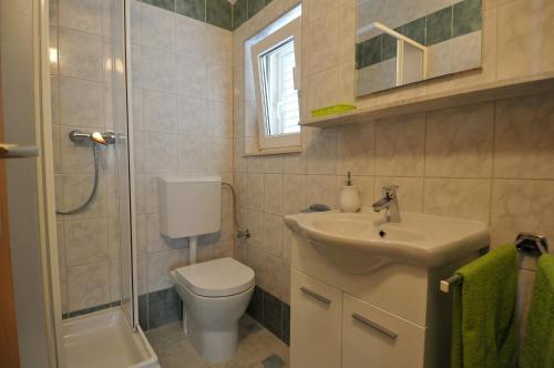 y baño con aseo, lavabo y ducha. en Apartments Bugenvila, en Cavtat