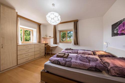 ein Schlafzimmer mit einem großen Bett und einem Kronleuchter in der Unterkunft Ferienwohnung Lafreid Algund in Algund