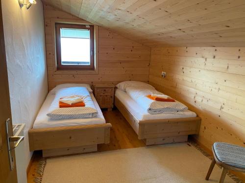 a room with two beds in a wooden cabin at Salvenalm in Hopfgarten im Brixental