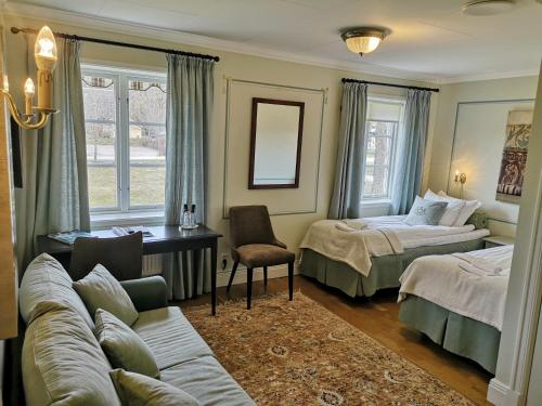 a hotel room with two beds and a couch at Färna Herrgård & Spa in Färna