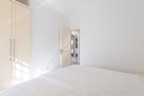 a white bedroom with a bed and a mirror at Bungalows Tisaya Golf in Maspalomas