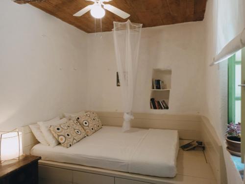 Cama en habitación con ventilador de techo en Hidesign Athens Traditional Stone House in Kea's Port, en Korissia