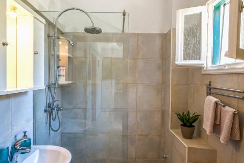 a bathroom with a shower and a sink at MANESSIS Apartments Kassiopi Bay Corfu in Kassiopi