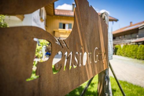 a wooden sign that reads mission club sitting on a fence at Pension Gimpl, Chiemgaukarte neu in Siegsdorf