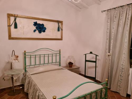 a bedroom with a bed and a picture on the wall at Agriturismo La Casa dei Ricordi in Collesalvetti