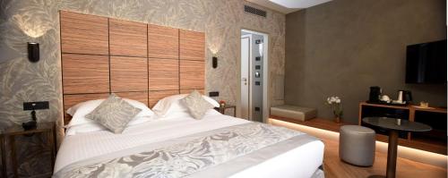 a bedroom with a large white bed with a wooden headboard at Rosa Salva Hotel in Venice