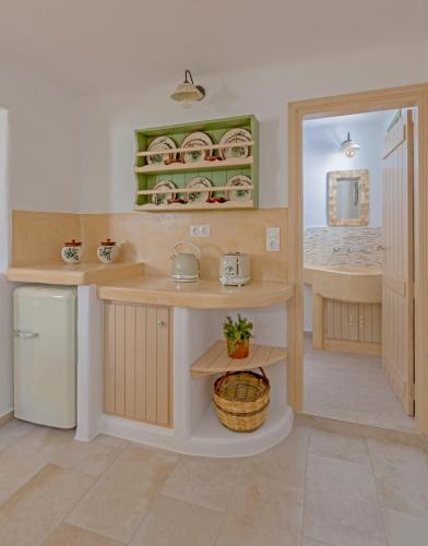 a kitchen with a counter and a sink and a refrigerator at Elia Traditional suites in Astypalaia