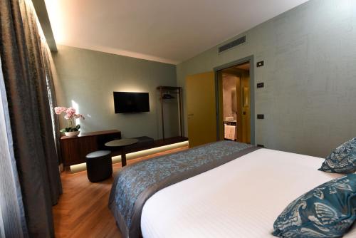 a hotel room with a bed and a television at Rosa Salva Hotel in Venice