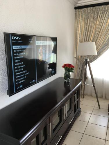 uma sala de estar com uma grande televisão de ecrã plano em Maso palace em Polokwane