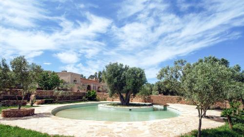 una piscina con un albero in mezzo a un cortile di Masseria Caretti Grande a Casalabate