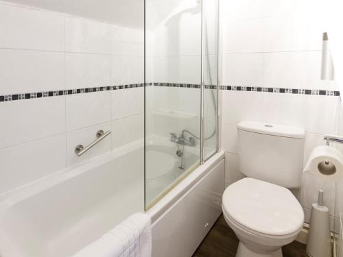 a white bathroom with a toilet and a shower at Elder Grove in Ambleside
