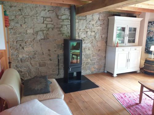 a fireplace in a living room with a stone wall at Gite de Miavoye calme nature chaleur vue in Onhaye