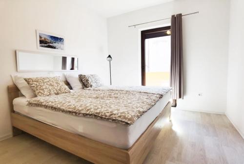 a white bedroom with a large bed with a window at Casa Sol Maris in Novigrad Istria