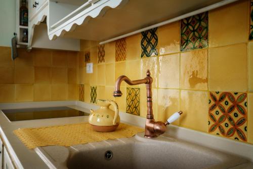 a kitchen sink with a faucet and a tea kettle on it at Le Viùzze Apartment in Tricase