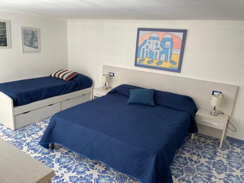 una camera con due letti con lenzuola blu di Casetta del pescatore a Ischia