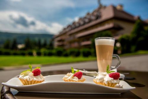 a plate with three cupcakes and a glass of beer at Hotel Stok in Wisła