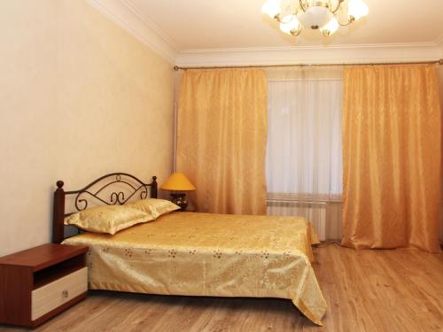 a bedroom with a bed and a chandelier at ApartLux Serpukhovskaya in Moscow