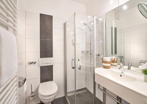 een badkamer met een douche, een toilet en een wastafel bij Parkhotel Nümbrecht in Nümbrecht