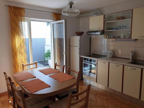 a kitchen with a table and a dining room at Apartment Kate in Omiš