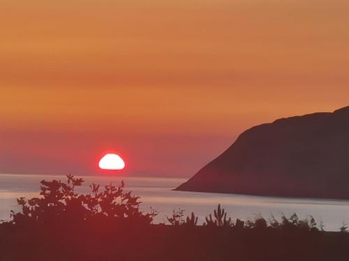 a sunset over the ocean with the sun in the sky at Bron Orme Private Hotel in Llandudno