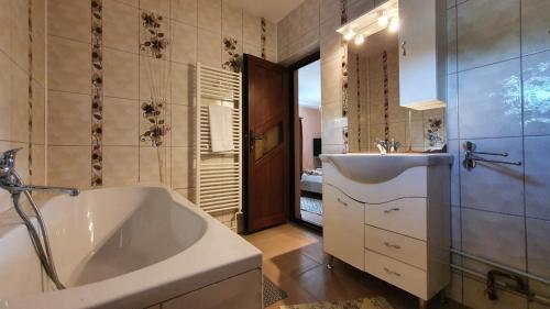 een badkamer met een groot bad en een wastafel bij La Mosu-n Retezat in Nucşoara