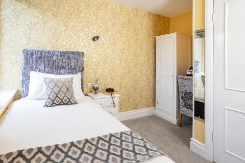 a bedroom with a bed and a yellow wall at Elder Grove in Ambleside