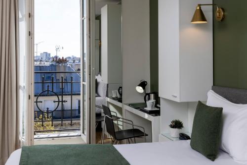 a hotel room with a bed and a balcony at Hôtel Brady in Paris