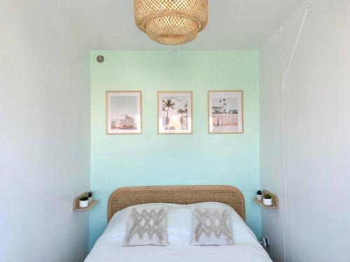 - une chambre avec un lit et trois photos sur le mur dans l'établissement « L’Olympe » - à 300 M de la plage, à Courseulles-sur-Mer