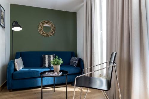 a living room with a blue couch and a table at Hôtel Brady in Paris