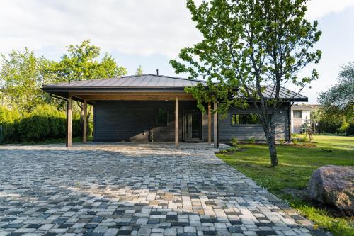 a house with a stone driveway in front of a house at Prieka Villa in Sigulda