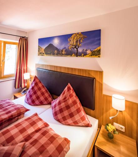 a hotel room with two beds and a tree on the wall at Pension Gimpl, Chiemgaukarte neu in Siegsdorf