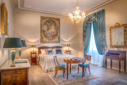 a bedroom with a bed and a table and chairs at Palazzo Cavagna Sangiuliani in Bereguardo
