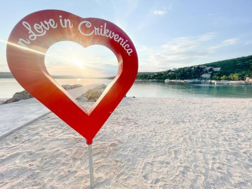 a heart sign on a beach with the words say stop in contingency at Apartman Anđelko in Jadranovo
