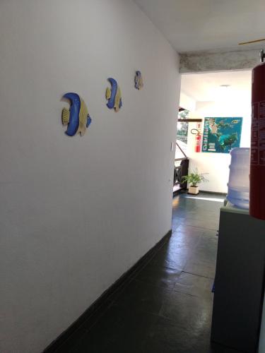 a white wall with a bunch of helmets on it at Suites Mar Azul Prainha in Arraial do Cabo