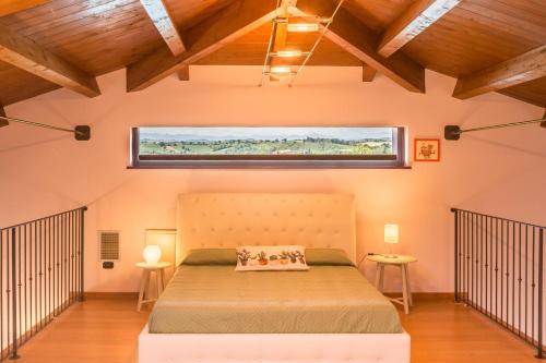 San CostanzoにあるVilla Saraの大きなベッドと窓のある寝室