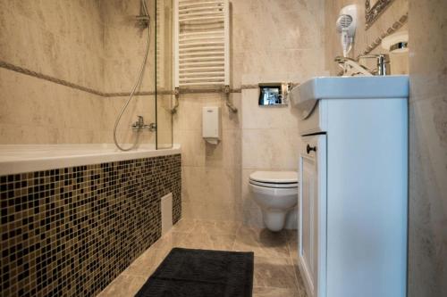 a bathroom with a tub and a toilet and a sink at Chalet Carpat Dream in Synevyr