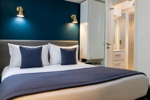 a bedroom with a large bed with blue walls at Hôtel Brady in Paris