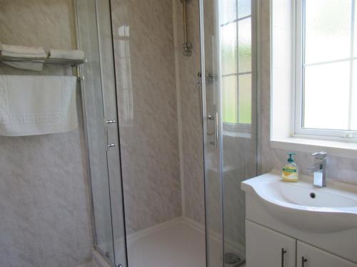 a bathroom with a shower and a sink at Foreshore House in New Romney